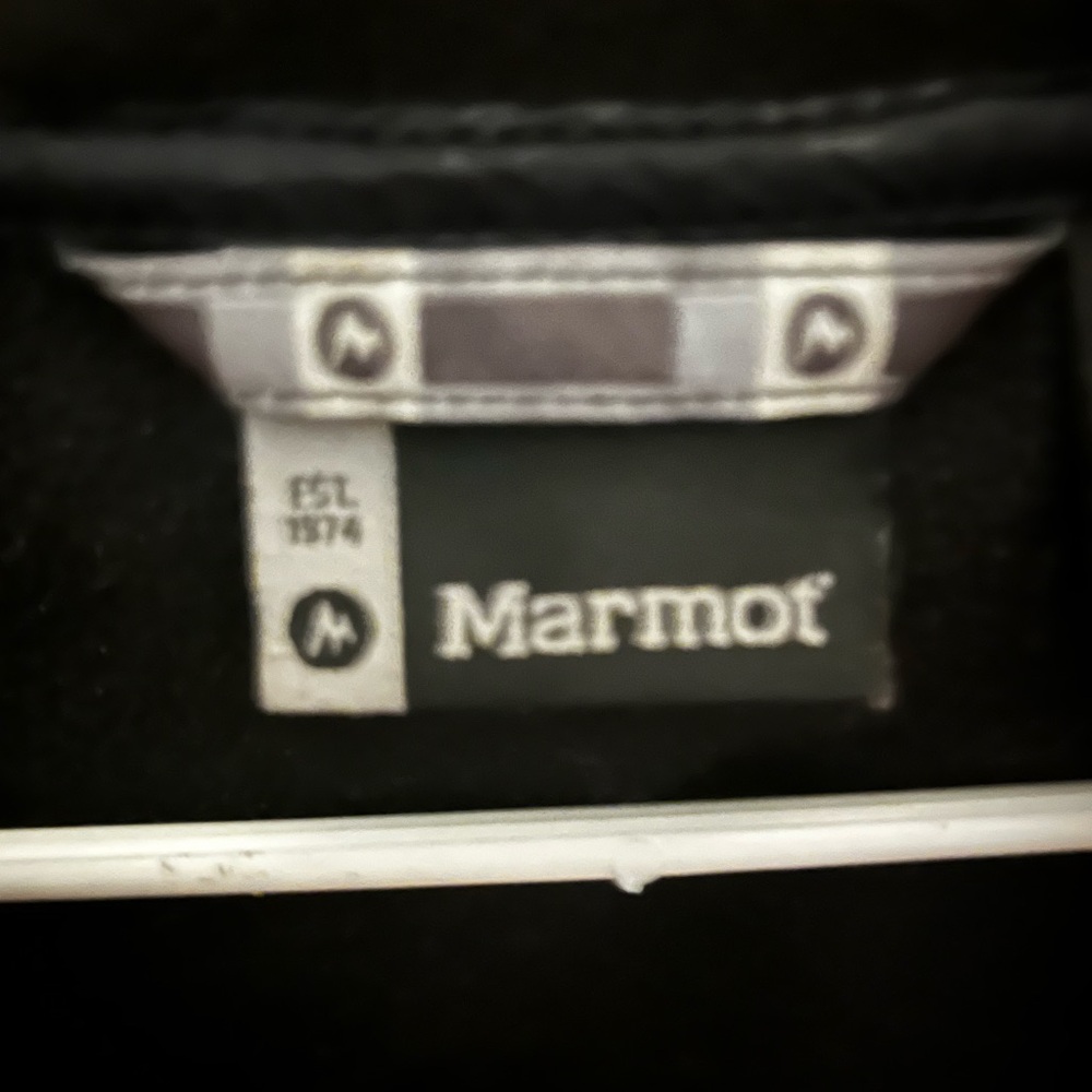 Marmot charcoal Black with faux fur lines around the hood , the cuffs.
